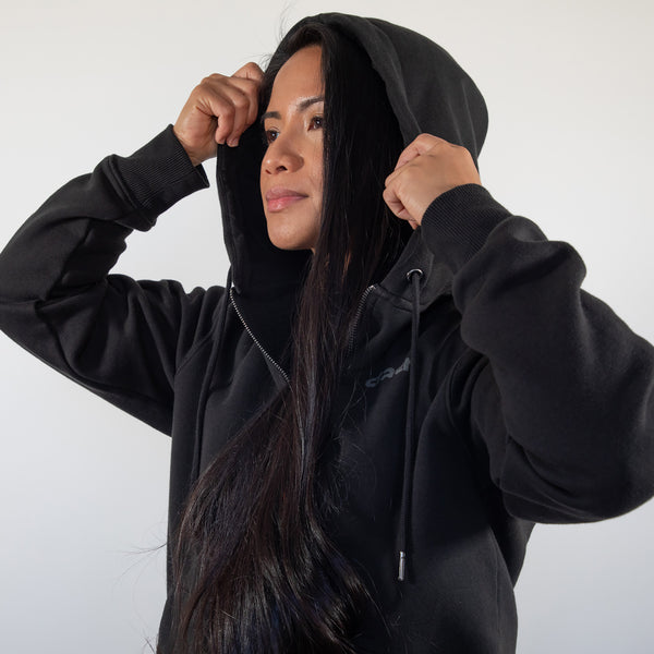 Model pulling up the hood of the black Stash Mix Hoodie